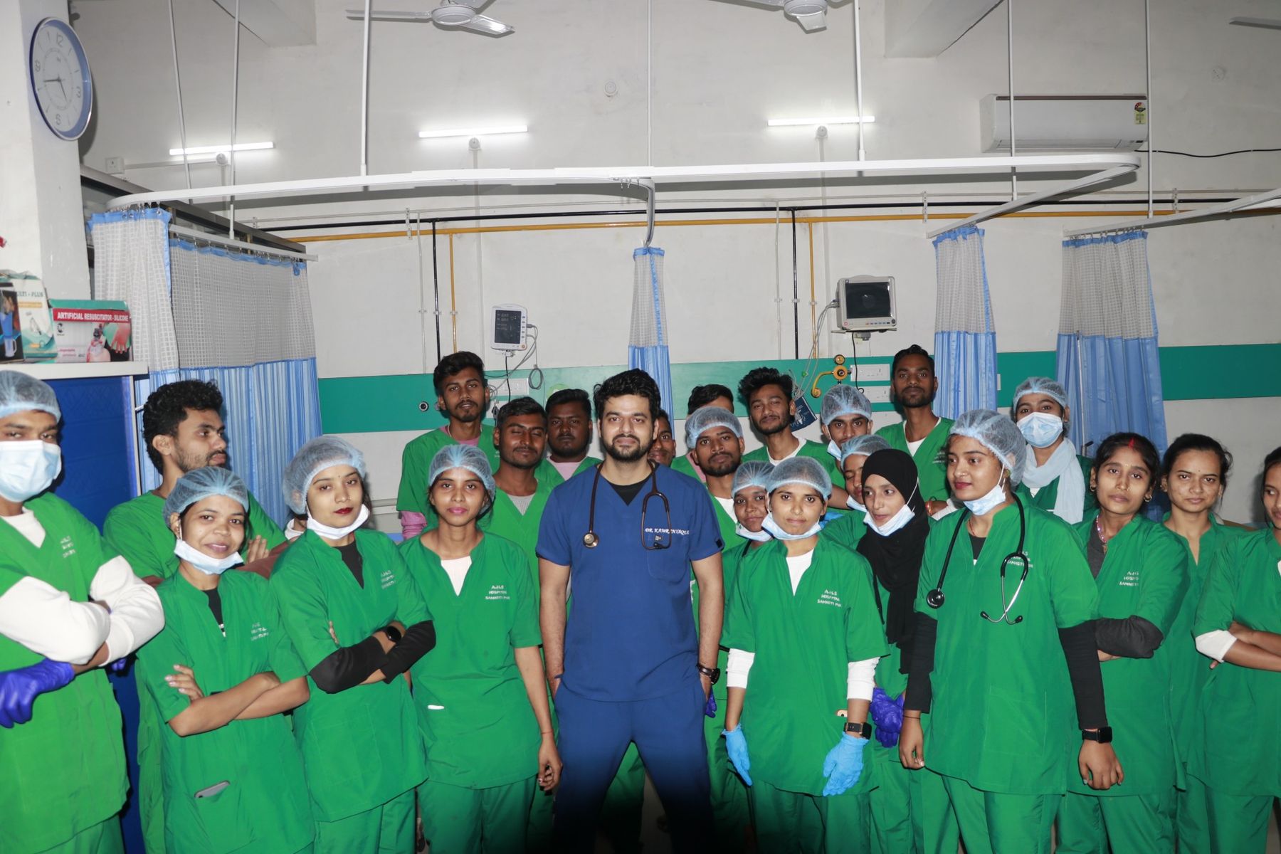 Students in AHS Hospital scrubs with their doctor